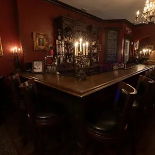 a bar with chairs and a chandelier