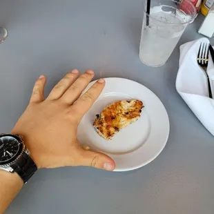 a person holding a slice of pizza on a plate