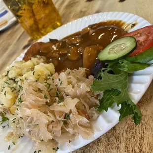 Schnitzel with mushroom sauce, potato salad and an extra side of kraut
