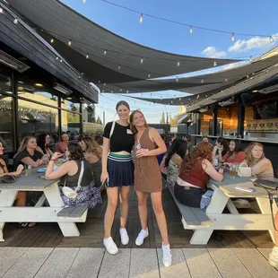 two women standing in front of picnic tables