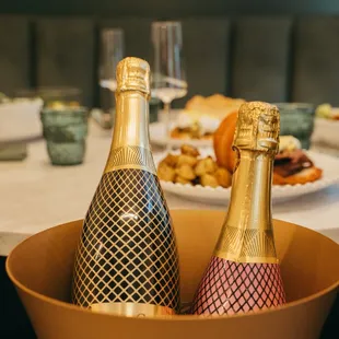 two bottles of champagne in a bowl