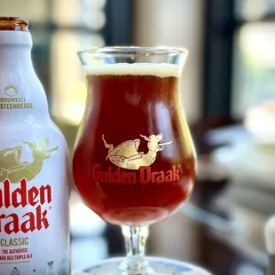 a glass of beer next to a bottle
