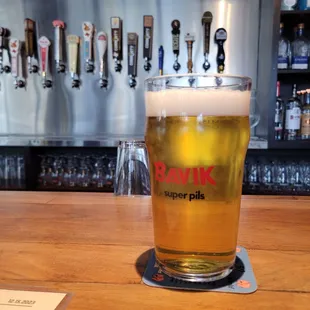 a glass of beer on a bar