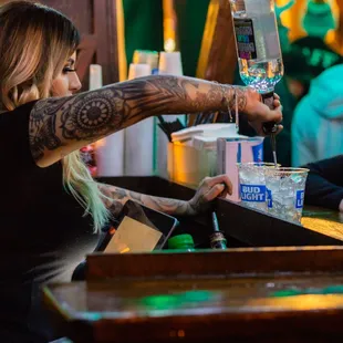 a woman pouring a drink at a bar