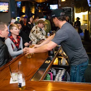 a man serving a woman at a bar