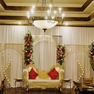 Engagement/ Anniversary setup. Elegant golden frame with flower garland with pink backdrop