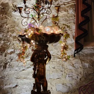 a statue of a woman holding a birdbath