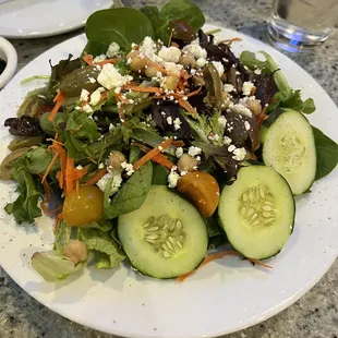 a salad with cucumbers, carrots, and feta cheese