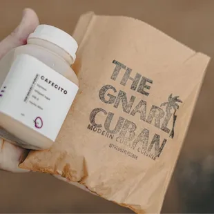a hand holding a bottle of gnarly cuban