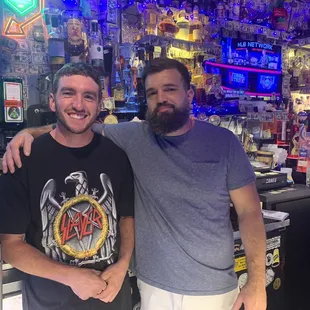 two men standing in front of a bar