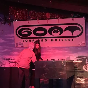 two people standing at a bar