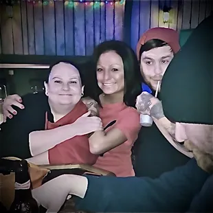 a man and two women with a drink