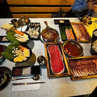 Tom Yum &amp; Sate (Spicy) Soup Bases, Wagyu Brisket, Wagyu Ribeyes, Assorted Seafood, Homemade Shrimp &amp; Beef Paste.