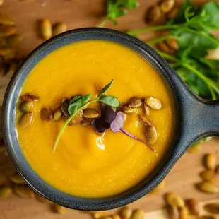 a bowl of carrot soup with a spoon