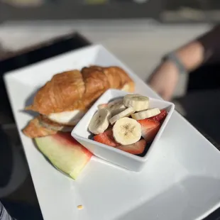 a plate of fruit and croissants