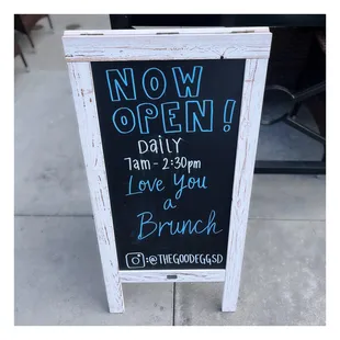 a chalk board with a sign that says now open