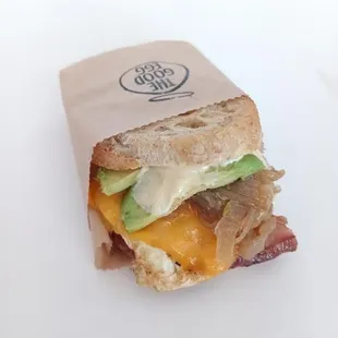 a sandwich with bacon, cheese and avocado