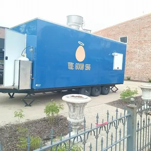 a blue food truck parked in front of a building