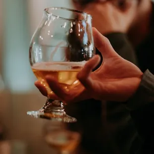 a person holding a glass of beer