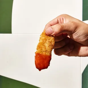 a hand holding a piece of food