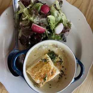 eggs en cocotte - two eggs baked in cream with ham, gruyere and herbs, topped with buttery puff pastry served with simple greens