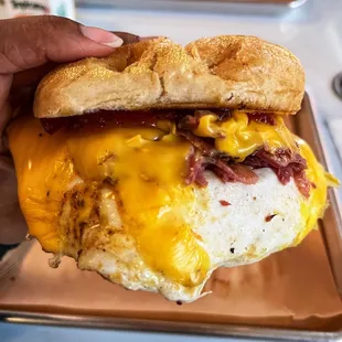 a person holding a breakfast sandwich