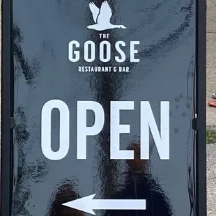 an open sign on the sidewalk