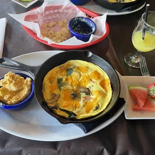 Spinach artichoke dip, frittata, beer cheese grits, fruit, and orange pineapple mimosa.