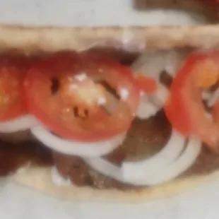 a sandwich with tomatoes and onions