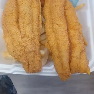 two fish sticks in a styrofoam container