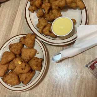 two plates of chicken nuggies and dipping sauce