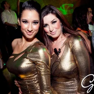 two women in gold dresses at a party