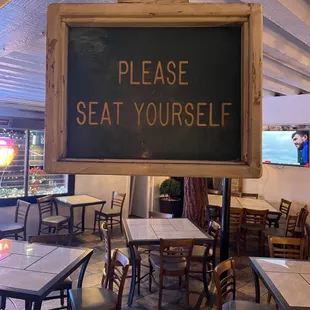 a sign saying please seat yourself