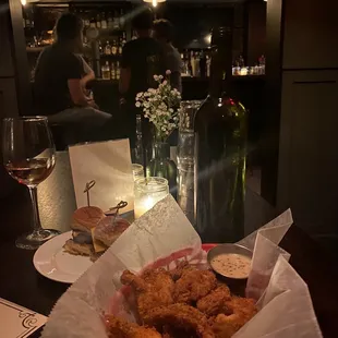 a basket of fried chicken and a glass of wine