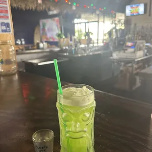 a drink in a mason jar with a green straw