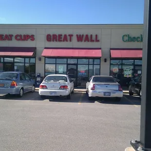 three cars parked in front of a great wall