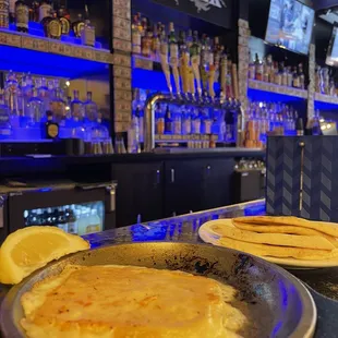 two plates of pancakes on a bar counter