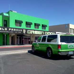 a van parked in front of a green building