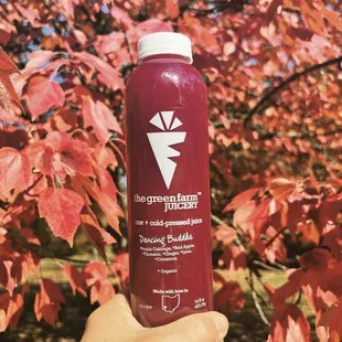 a hand holding a bottle of juice