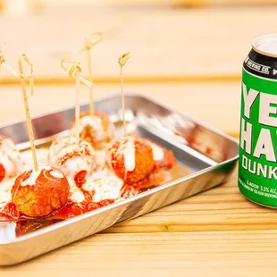 a can of beer and a tray of meatballs