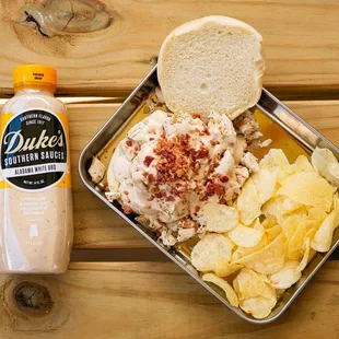 a sandwich and chips in a tin