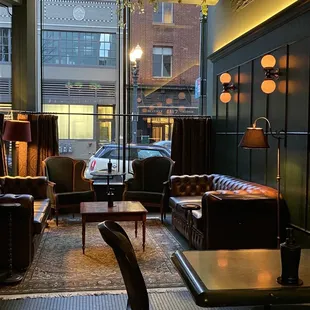 a couch, chairs, tables, and a car in the background