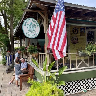 two people sitting on a bench in front of a restaurant