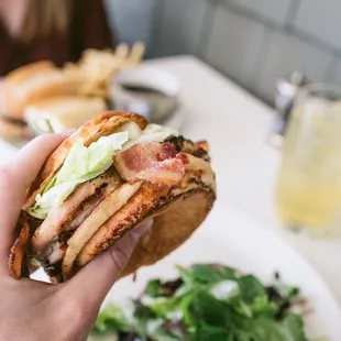 a person holding a sandwich