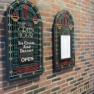 two signs on a brick wall