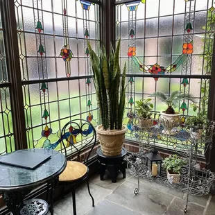 a table and chairs in front of a stained glass window