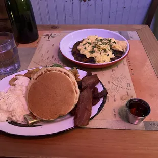 a breakfast of pancakes, eggs, bacon, and hash browns