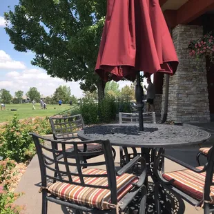 a table with four chairs and an umbrella