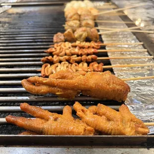 a line of chicken skewers on a grill