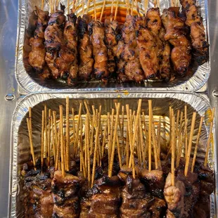 two trays of meat skewers